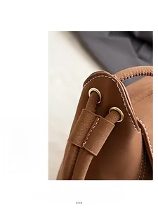 Detailed macro view of brown lychee grain leather bucket bag with gold drawstring eyelets