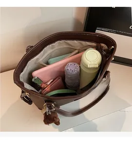 Macro view of spacious brown tote bag interior with storage capacity and teddy charm