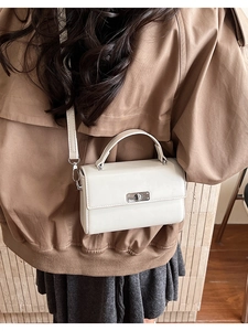 Détail du sac bandoulière en cuir crème avec fermoir rotatif argenté et poignée fixe