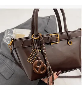 Close-up of dark brown vintage bucket bag with gold buckle and unique charms