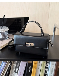 Gros plan d'un sac à main en cuir verni noir avec fermoir métallique argenté élégant