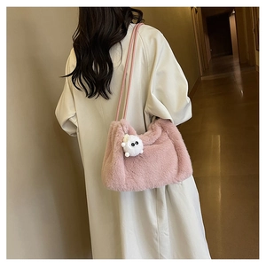Borsa a secchiello in peluche rosa sulla spalla di un modello con morbida pelliccia sintetica