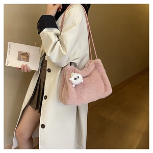 Dettaglio della borsa a secchiello in peluche rosa con ciondolo mostro e tracolla sottile