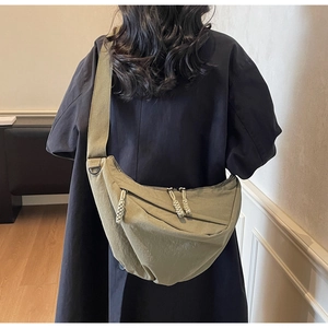 Detail of khaki crescent crossbody bag showing durable nylon fabric and wide shoulder strap