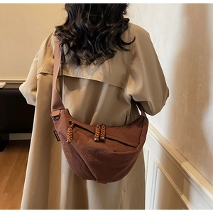 Brown nylon crescent bag detail showing large capacity, zipper pulls, and adjustable strap