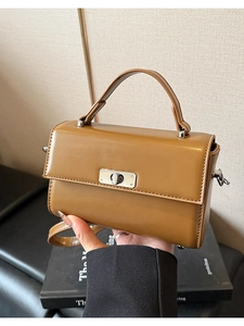 Détail du sac carré marron caramel avec fermoir tournant en métal argenté et poignée