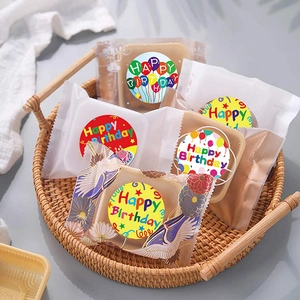 Colorful Happy Birthday roll stickers on food packaging in a rustic woven basket