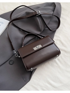Détail du sac à rabat marron foncé avec fermoir rotatif argenté et clous de protection