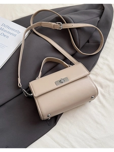 Vue macro du sac en cuir beige avec fermoir rotatif argenté et détail de la poignée