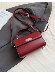 Vue détaillée d'un petit sac carré en cuir bordeaux avec fermoir argenté et poignée