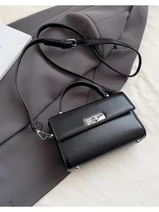 Détail du sac à main en cuir PU noir avec fermoir rotatif argenté et bandoulière réglable