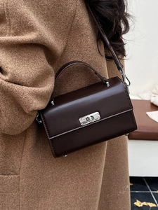 Sac à main classique marron foncé en similicuir avec fermoir rotatif argenté porté
