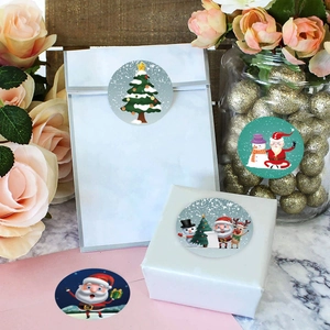 8 runde Weihnachtsaufkleber mit Weihnachtsmann und Schneemann auf Geschenkverpackung