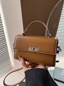 Sac à main vintage marron avec fermoir rotatif argenté dans un décor de style de vie