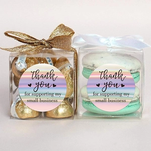 Rainbow holographic thank you stickers on clear gift boxes with macarons and chocolates