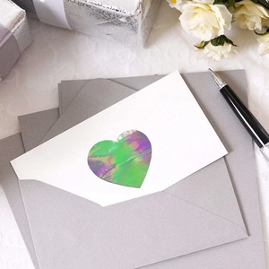 Holographic heart stickers 25mm on a white card with elegant wedding envelope setup