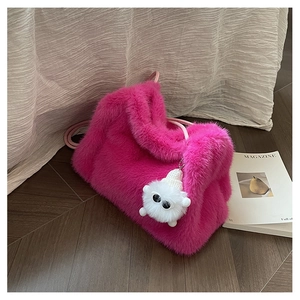 Dettaglio della borsa a secchiello in ecopelliccia fucsia con ciondolo di peluche