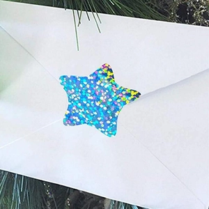 Macro shot of a blue laser glitter star sticker sealing a white envelope for gift wrapping