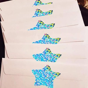 Detail of laser glitter star stickers on pink envelopes for gift packaging