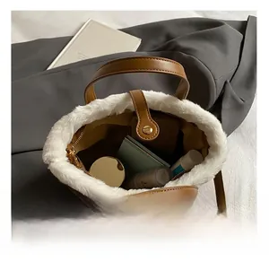 Internal capacity of brown leather bucket bag with white faux fur trim and daily items