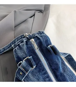 Dettaglio della cerniera in metallo su borsa bowling in denim blu con fibbie argentate