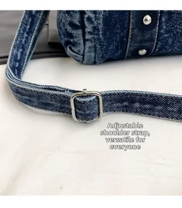 Dettaglio della tracolla regolabile in denim con fibbia in metallo argento sulla borsa