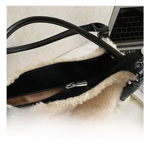 Detail shot of the plush beige fleece bag featuring a sleek black leather strap and metal zipper