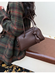 Nahaufnahme der dunkelbraunen Boston-Tasche mit Lychee-Struktur und Knotengriff-Detail