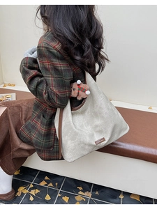 Détail du cabas beige vintage avec bordure marron et charm ours en peluche sur mannequin
