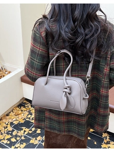 Dettaglio borsa Boston grigio scuro in pelle martellata con nodo decorativo e ganci metallici