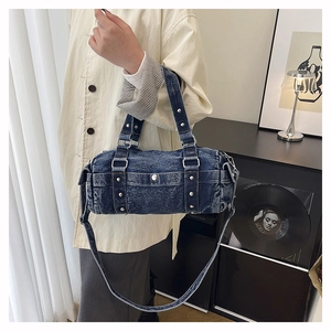 Dettaglio ravvicinato della borsa bowling in denim blu con borchie metalliche argentate
