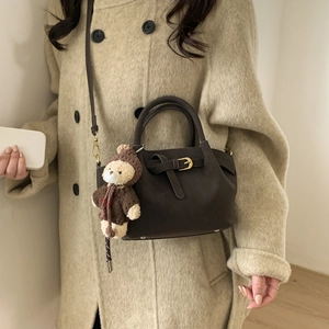 Women's dark brown suede bucket bag with a teddy bear charm for autumn styling