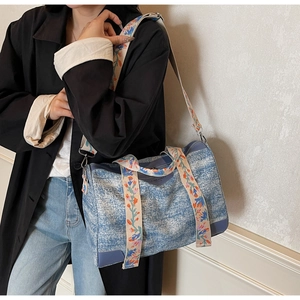 Detail of blue canvas tote bag featuring an ethnic floral embroidered wide strap