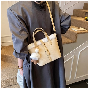 Close-up of creamy faux fur bucket bag featuring plush trim and soft leather straps