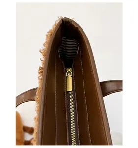 Detail of high-quality golden zipper and striped lining on brown lamb wool tote bag