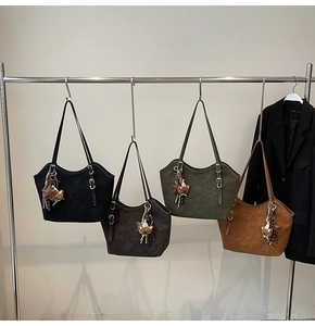 Detail of four retro matte leather tote bags in various colors with cute bear charms