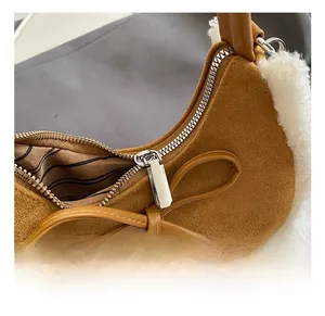 Détail du sac en daim caramel avec bordure en peluche blanche et nœud métallique argenté