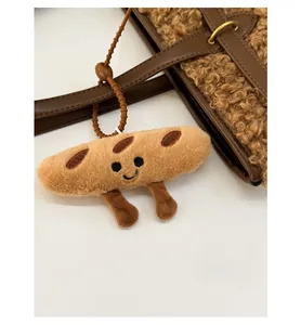 Close-up of a cute plush bread charm with smiley face on a fuzzy brown tote bag