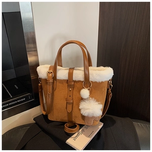 Detail of vintage brown suede bucket bag featuring white faux fur trim and adjustable strap