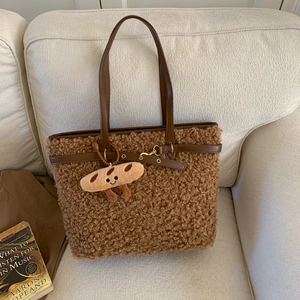 Detailed texture of brown teddy fur tote bag with cute toast pendant on beige sofa