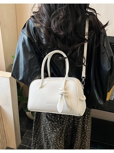 Detailansicht der weißen Boston Bag aus Leder mit modischer Schleife und Schultergurt