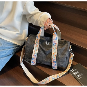 Detail of grey canvas Boston bag featuring colorful floral embroidered wide straps