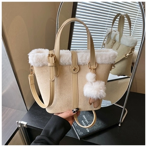 Detail of beige suede bucket bag featuring plush faux fur trim and gold hardware