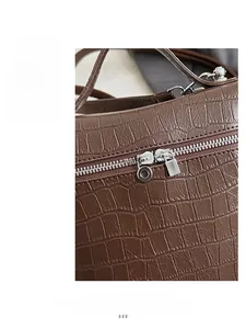 Detail of brown crocodile pattern PU leather with smooth silver double metal zippers