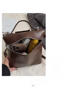 Detail of a dark brown crocodile pattern bucket bag showing large interior storage space