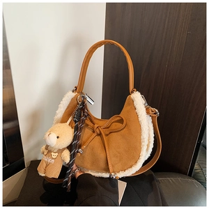 Détail du sac en daim caramel avec bordure en peau lainée et breloque ours sur le côté