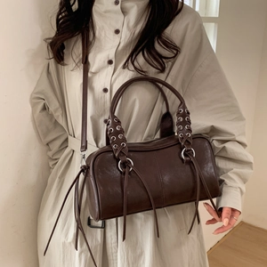 Détail du sac Boston marron foncé en cuir avec glands et anneaux en argent sur modèle