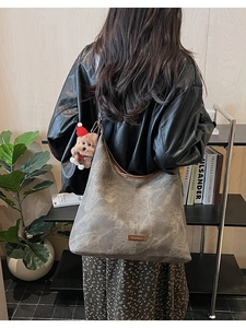 Gray marble pattern tote bag featuring brown leather trim and a cute plush bear charm