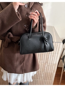 Nahaufnahme der schwarzen Boston-Tasche mit Kieselleder-Textur und Knoten-Detail