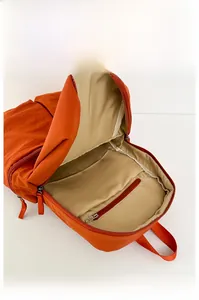 Detail of the orange backpack interior showing a large main compartment and zip pocket